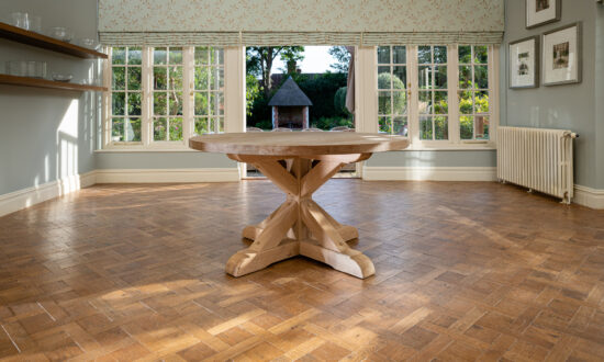 Oxenwood's wooden aubrey circular dining table shown in a parquet floored dining room