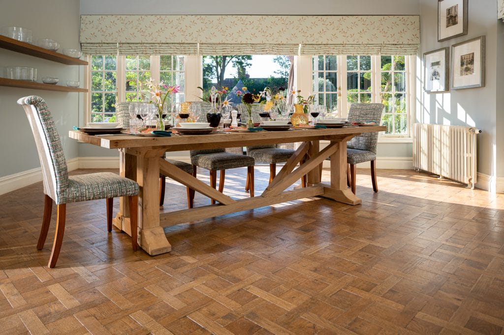 A laid indoor wooden dining table with cushioned high chairs