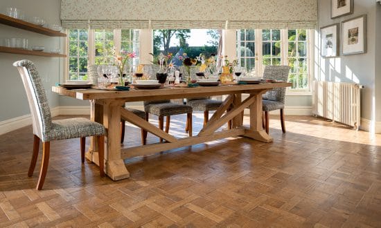 A laid indoor wooden dining table with cushioned high chairs