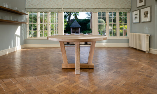 Oxenwood's wooden quintus circular dining table shown in a parquet floored dining room