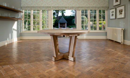 Oxenwood's wooden quintus circular dining table shown in a parquet floored dining room