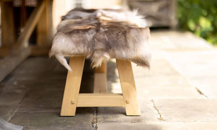Oxenwood's Reindeer Hide Blankets on a wooden bench
