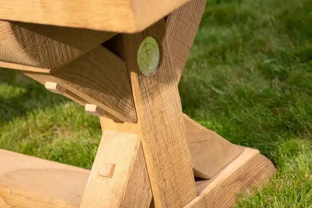 Wooden outdoor bench detail in a grassy garden and patio area