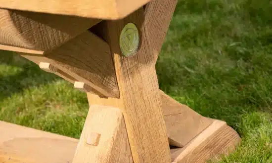 Wooden outdoor bench detail in a grassy garden and patio area