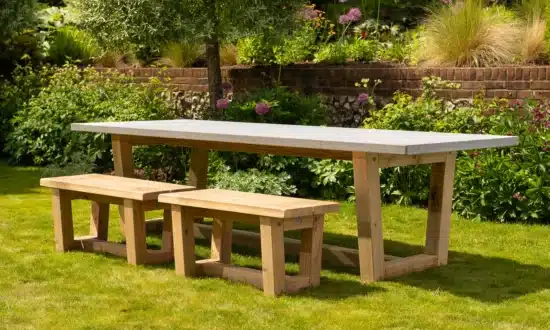 Bluestone topped outdoor dining table with benches in a grassy garden
