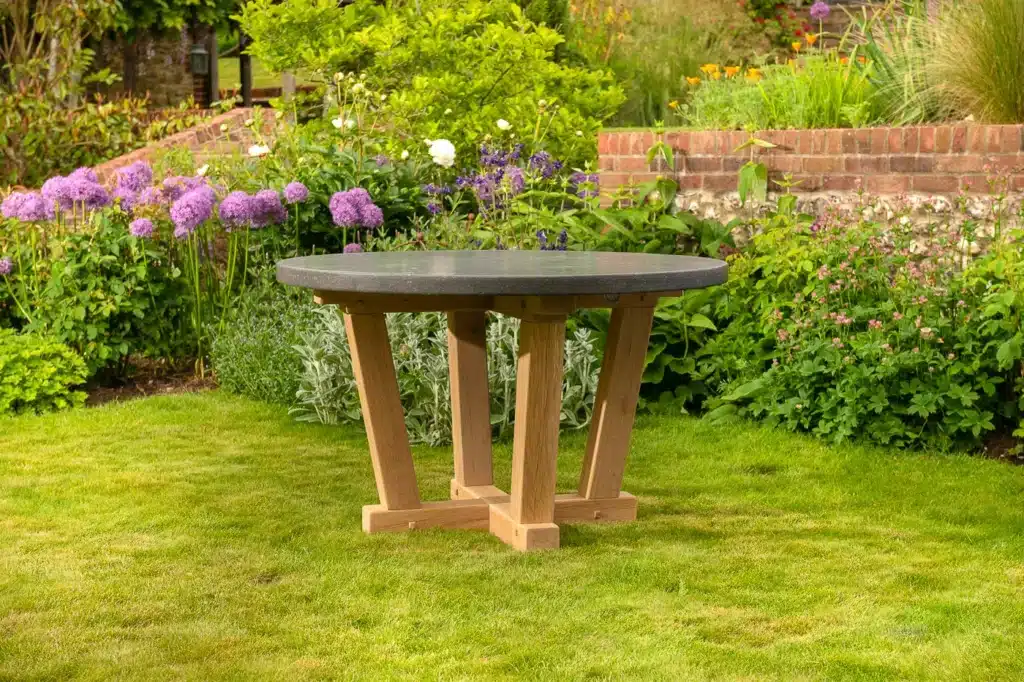 Oxenwood's circular outdoor dining table on a grassy garden area