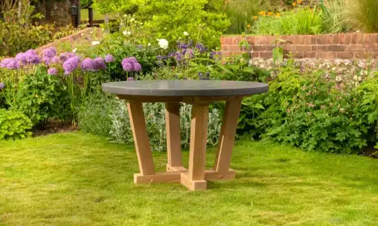 Oxenwood's circular outdoor dining table on a grassy garden area