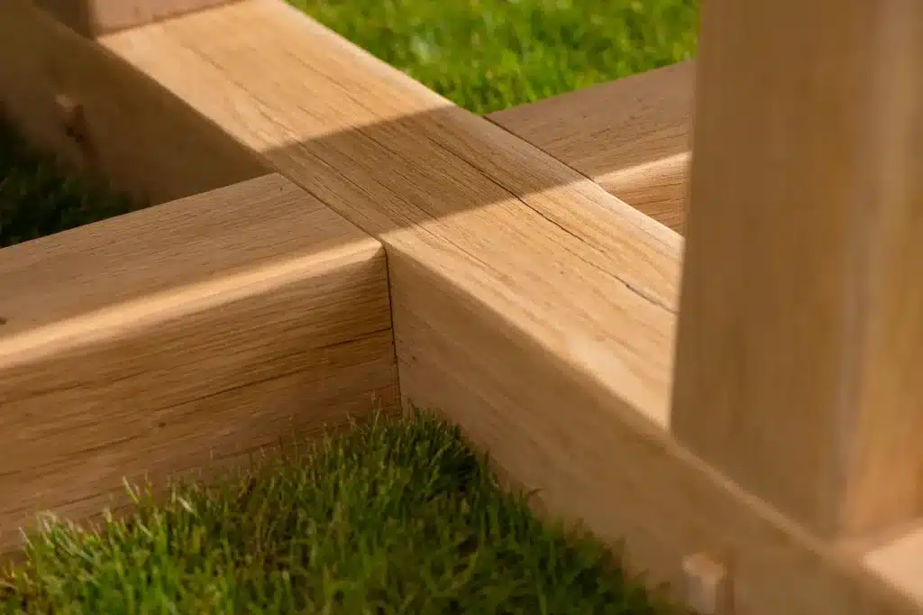 Oxenwood's circular outdoor dining table surrounded by woven dining chairs on a grassy garden area